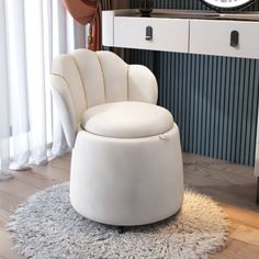 a white chair sitting on top of a rug in front of a table with a clock