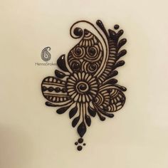 an intricately designed wall hanging on the side of a white wall with black and brown designs