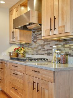 a kitchen with wooden cabinets and granite counter tops, along with an oven hood over the stove