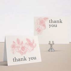 two thank you cards sitting on top of a table next to a faucet