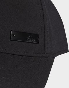 the back of a black baseball cap with a metal badge on it's side