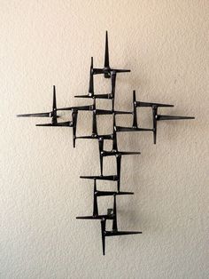 a wall mounted clock with multiple pieces of black metal on it's face and sides