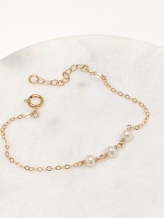 "Our gift to you 10% off your first purchase. Details here - http:/eepurl.com/dpVPBz The perfect pearl bracelet. One, two or three dainty pearls are suspended on our signature chain. Perfect for that special occasion yet simple enough for everyday wear. Layer them together or with other favorites DETAILS 14 k fill or Sterling Silver. Pearls are approximately 3 mm. Each freshwater pearl is unique meaning the size and shape may vary slightly. Comes with a 1\" extender chain to fine tune your fit. Minimalist Pearl Bracelet With Extender, Pearl Bracelet With Adjustable Chain As Gift, Everyday Pearl Bracelets With Adjustable Chain, Everyday Minimalist Pearl Bracelet With Extender, Everyday Delicate Pearl Chain Bracelet, Adjustable Pearl Bracelet With Delicate Chain, Pearl Jewelry With Extender As Gift, Classic Pearl Bracelet With Adjustable Chain For Gifts, Minimalist Pearl Bracelets With Pearl Chain