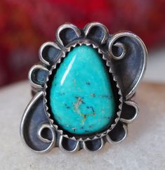 Turquoise Teardrop Ring, Sawtooth Bezel, Framed in Whimsical Scrolls, Sterling Silver. Ring size just under 6. Stone is approximately 6/8th inch long.  Item is in good condition.  This piece is one of many from a collection purchased from a Vermont woman, who traveled to the southwest every winter, for decades. Each trip, she would purchase a piece of silver to remember her time in the desert. Each piece has been cleaned, however, I left plenty of patina!  If you are unsatisfied with your purchase, please contact me within 7 days and return the item within 14 days of purchase for a full refund. I am happy to answer any questions you may have. Collectible Teardrop Turquoise Jewelry, Southwestern Blue Turquoise Teardrop Ring, Bohemian Blue Teardrop Ring, Handmade Blue Turquoise Teardrop Ring, Handmade Teardrop Turquoise Ring, Handmade Turquoise Teardrop Ring, Southwestern Blue Teardrop Ring, Southwestern Teardrop Blue Rings, Southwestern Adjustable Teardrop Jewelry