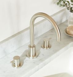 a bathroom sink with two faucets and a soap dispenser