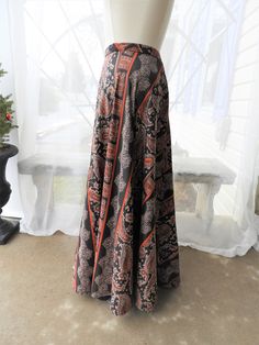 "AWESOME Vtg 1970's Jedezet Black & Orange Paisley Polyester Lined Full Length Maxi Skirt sz S/M I'm a huge fan of paisley so I couldn't believe my luck when I came across this vintage 1970's maxi skirt! It has a high waist with 2 buttons to adjust the waist. The fabric is Polymide...a type of polyester I assume. There is a DuPont label here also. The skirt flares nicely at the bottom and is just classic 1970's. The paisley pattern is in orange, off white and gray set on a black back ground. The Bohemian Long Skirt With Paisley Print, Bohemian Long Maxi Skirt With Paisley Print, Vintage Flowy Maxi Skirt, Vintage Full-length Lined Skirt, Black Bohemian Flowy Wrap Skirt, Black Flowy Bohemian Wrap Skirt, Bohemian Black Flowy Wrap Skirt, Vintage Skirt For Festival, Bohemian Fitted Skirt With Paisley Print