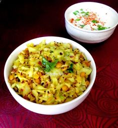 two bowls filled with food sitting on top of a red tablecloth next to each other