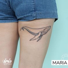 a woman's thigh with a tattoo of a whale on it