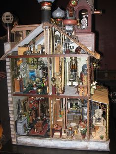 a doll house made out of wood and assorted items in it's display case