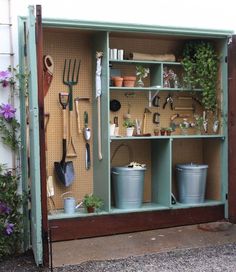 an outdoor garden storage unit with gardening utensils and plants on it's shelves