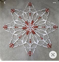 a white and red snowflake sitting on the ground