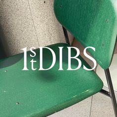 a green chair sitting next to a wall with the words idbs on it's side