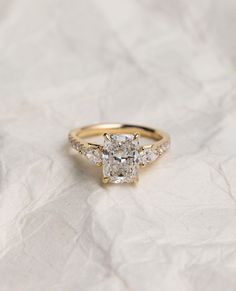 a yellow gold engagement ring with three stones on top and the center stone in the middle