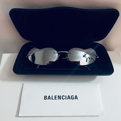 Authentic Balenciaga Glasant 0179 Ruthenium Silver Mirrored Fashion Sunglasses Bb0179s 002 - New Without Tag. Size 60-18-135 New With Case. Never Worn, One Tiny Pinpoint Size Dot On Lens, Almost Imperceptible When Looking At It And Not Noticeable At All While Wearing. See Our Photos For Details. Dot Looks Much Smaller When Looking Directly At The Lens Than In The Photo Which Is Highly Magnified Because We Wanted To Bring Awareness To It. Silver Cat Eye Sunglasses For Formal Occasions, Silver Rimless Sunglasses For Evening, Silver Rimless Evening Sunglasses, Silver Rimless Sunglasses For Formal Occasions, Designer Silver Sunglasses For Formal Occasions, Fashion Mirror, Silver Mirrors, Fashion Sunglasses, Sunglasses Accessories