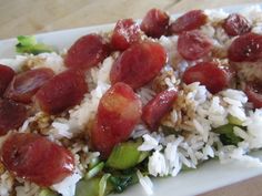 a white plate topped with rice covered in meat and veggies on top of it