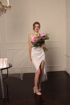 a woman in a wedding dress holding flowers