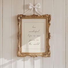 a gold frame with a white bow hanging on the wall next to a sign that reads, we are wonderful life is not given in the world