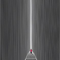 a person walking up some stairs in the middle of a room with vertical lines on it