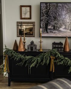 a christmas mantle with candles and decorations on it