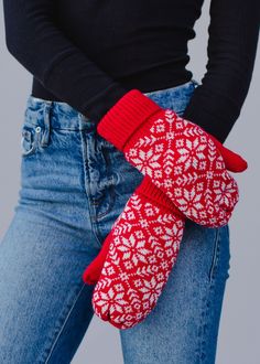 a woman is wearing red mittens and holding her hand in the other side of her pocket