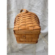 a woven basket sitting on top of a white sheet