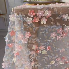 the table cloth has flowers on it and is covered in sheer fabric with sequins