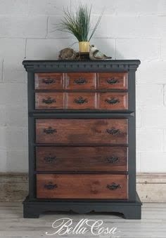 an old dresser is painted black and brown