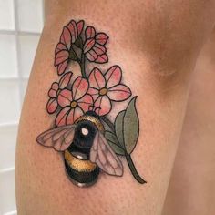 a tattoo with flowers and a bee on it