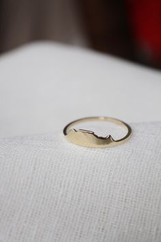 a gold ring sitting on top of a white pillow