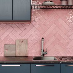 a kitchen with blue cabinets and pink tile backsplash, stainless steel faucet