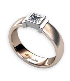 a white gold ring with a princess cut diamond on the top and side, set in 18k yellow gold