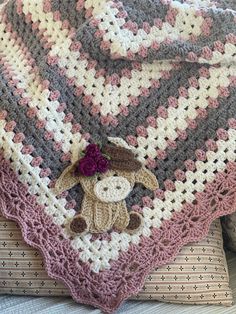 a crocheted blanket with a teddy bear on it