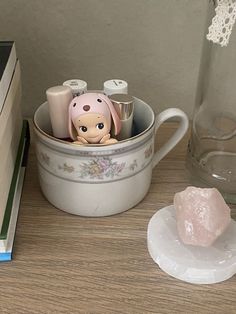 a cup filled with stuff sitting on top of a table next to a pile of books