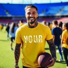 a man in a yellow shirt holding a basketball on a field with people walking around