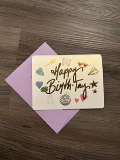 a birthday card with the words happy birthday written on it next to a purple envelope