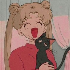 a woman holding a black cat with her mouth open and tongue out in front of the camera