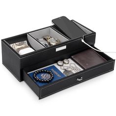 an open black leather jewelry box filled with personal items