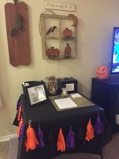 a table that has some decorations on it and a tv in the background with pumpkins