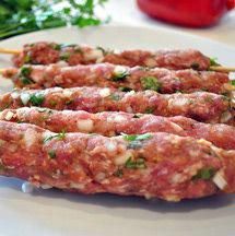 meat skewers on a white plate with parsley