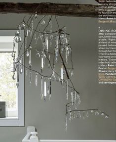 a chandelier hanging from the ceiling in a room with gray walls and white trim