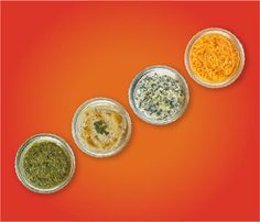 three bowls with different types of sauces in them on an orange and red background