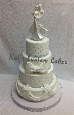 a three tiered wedding cake with a bride and groom figurine on top