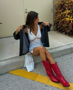 girl sitting on curb wearing white lace dress with red cowboy boots Coastal 70s Fashion, Subtle Nashville Outfits, Long Shorts And Cowboy Boots, Costal Cowgirl Outfits, Acl Outfits, 70s Cowgirl, Nashville Fits, Nashville 2023, Mode Coachella