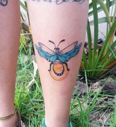 a woman's leg with a tattoo on it that has a blue and yellow bee