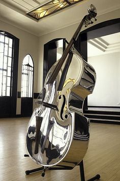 a large metal contraption sitting on top of a hard wood floor next to windows