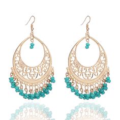 a pair of gold earrings with turquoise beads and filigrees on the hoop