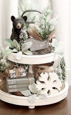 a bear statue sitting on top of a white shelf filled with books and christmas decorations