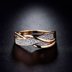 a gold ring with two rows of diamonds in it on a black surface, close up