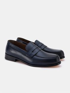 Color: navy Cow leather with natural finish Penny front Leather insoles Rubber and leather soles Hand-stitched detailing Classic Blue Slip-ons For Business, Blue Business Loafers With Rubber Sole, Business Blue Loafers With Rubber Sole, Blue Classic Tassel Loafers For Business, Classic Blue Tassel Loafers For Business, Navy Leather Wingtip Shoes With Leather Sole, Business Slip-on Boat Shoes With Leather Footbed, Business Boat Shoes With Leather Footbed And Round Toe, Navy Leather Business Loafers