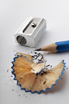 a pencil and sharpener sitting on top of a piece of paper next to a broken pencil